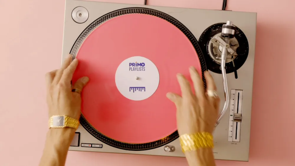 Hands scratching a pink record on a turntable